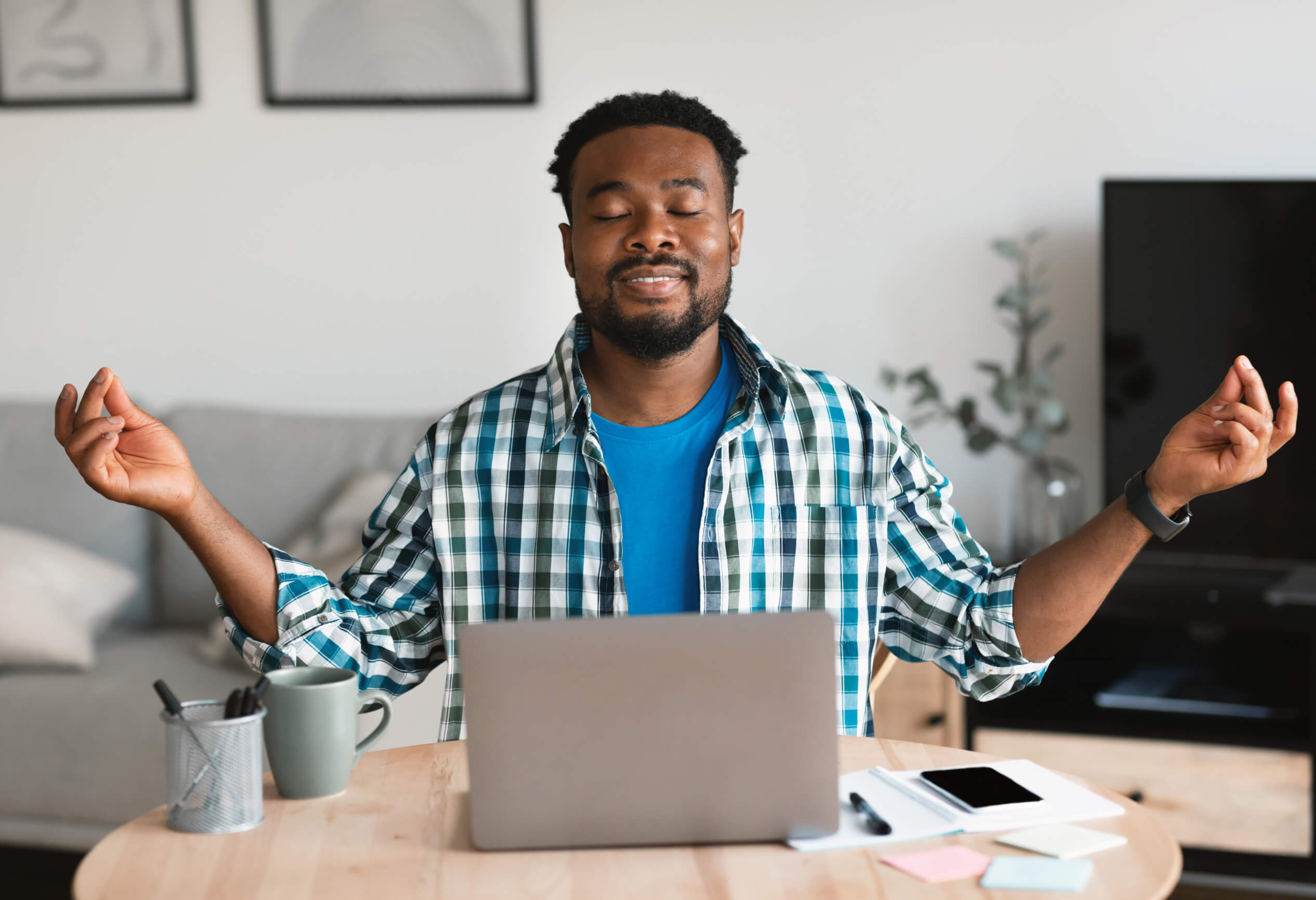 man meditating in front of laptop