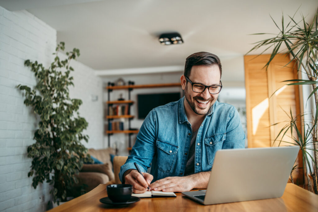 Portrait of a happy man taking notes.