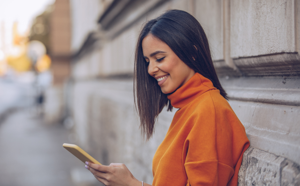 woman smiling at phone screen