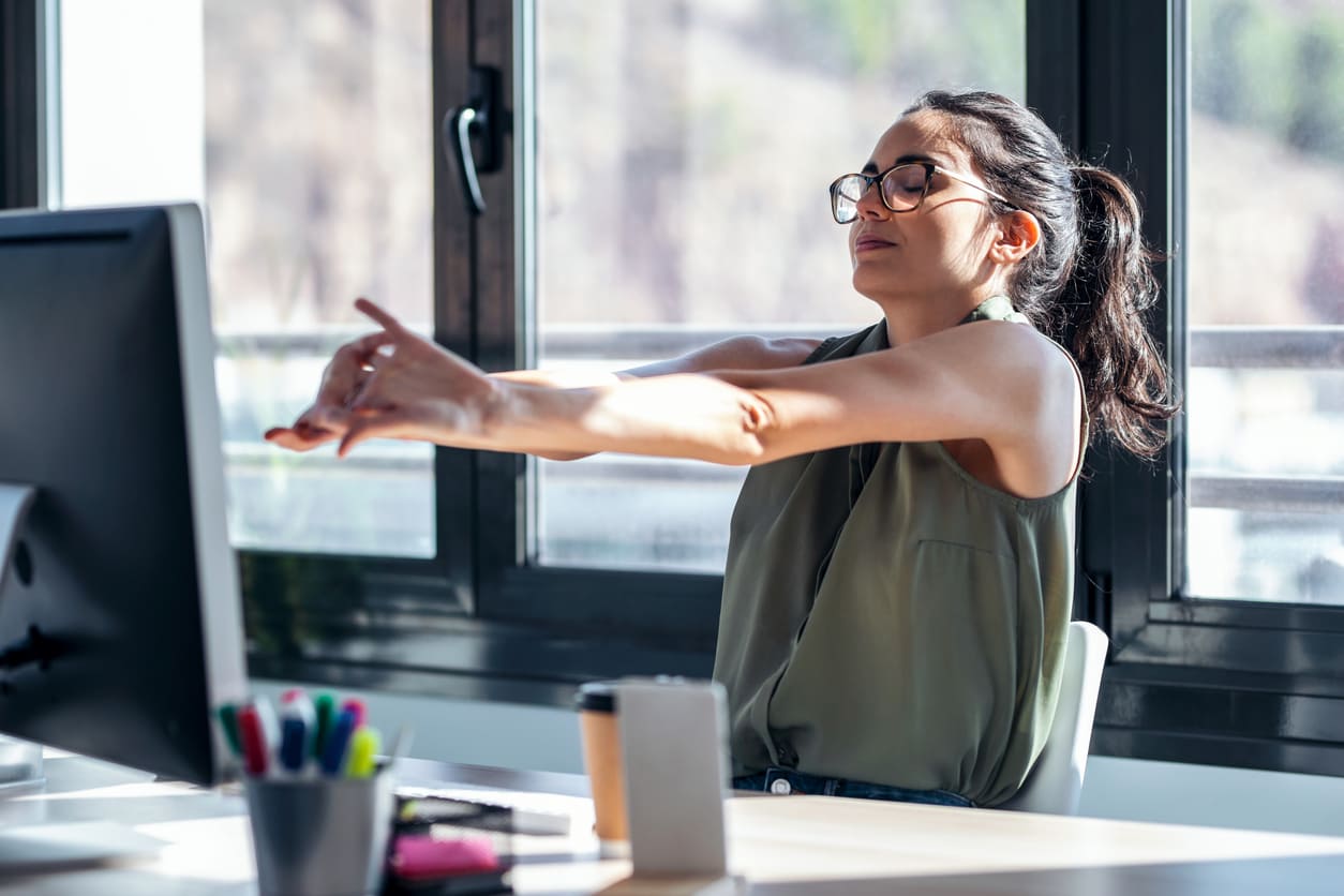 woman stretching at desk