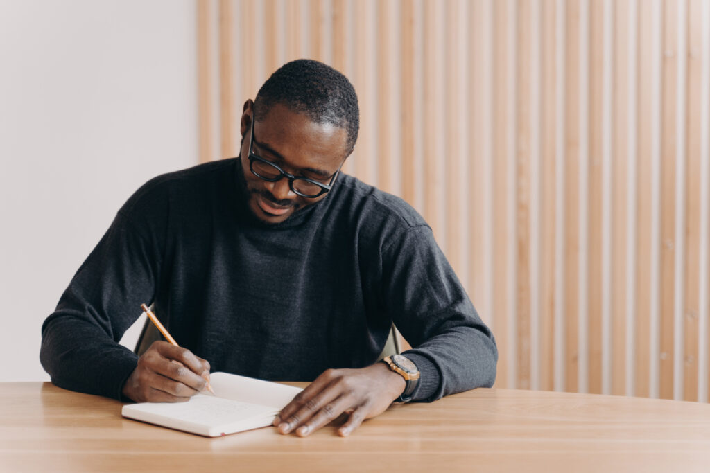 man journaling at desk